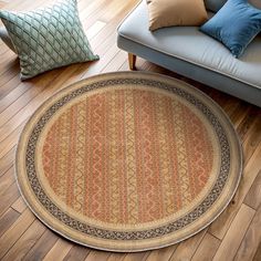 a round rug on the floor in front of a couch with pillows and throw pillows