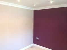 an empty room with purple walls and white trim on the wall is pictured in this image