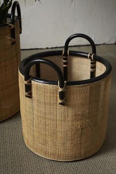 two woven baskets with handles on the floor