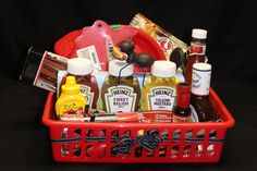 a red basket filled with condiments and condiments on top of a black table