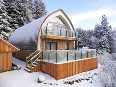 a wooden building with a glass balcony in the snow