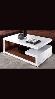 a white coffee table sitting on top of a carpeted floor next to a brown couch