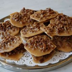 several cookies with pecans and caramel are on a doily