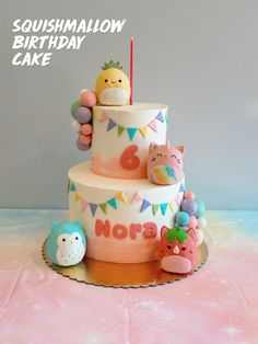 there is a cake with animals on it and the words squishmalow birthday cake