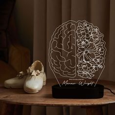 a pair of white shoes sitting on top of a wooden table next to a lamp