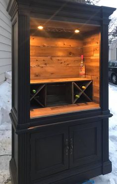 an outdoor bar in the snow with lights on and shelves built into it's sides