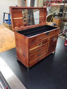 an old wooden chest on wheels with a mirror in it