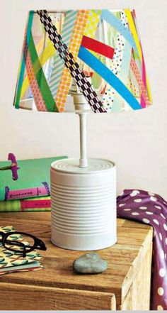 a lamp that is sitting on top of a wooden table in front of a pile of books