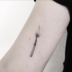 a small wrench tattoo on the left inner arm, with a diamond in it