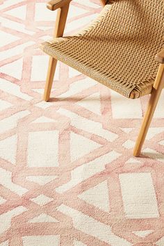 a chair sitting on top of a pink rug next to a wooden table and chairs