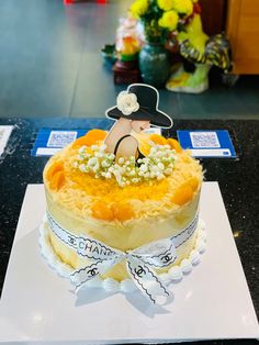 there is a cake that has been decorated with flowers and a lady's hat on top