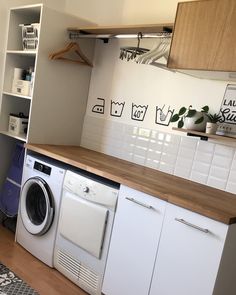 a washer and dryer sitting in a kitchen next to each other on top of a wooden counter