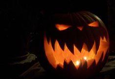 a carved pumpkin with glowing eyes in the dark