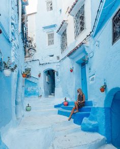 a woman sitting on steps in the blue city