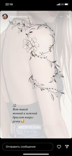 the back of a woman's shoulder with flowers and leaves tattoo design on it