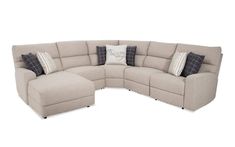 a large sectional couch with pillows on the top and bottom corner, in beige fabric