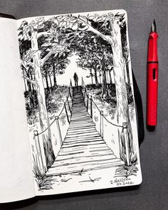 an open notebook with a drawing of a person walking down a path in the woods