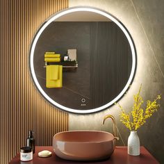 a bathroom with a round mirror and yellow towels