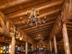 a chandelier hanging from the ceiling in a large room with tables and chairs