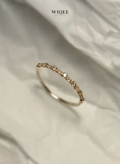 an image of a gold ring with diamonds on white paper background, close up photo