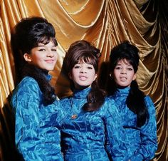 three women in blue outfits standing next to each other