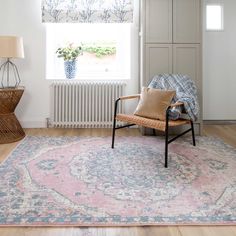 a living room with a chair, rug and radiator next to the window