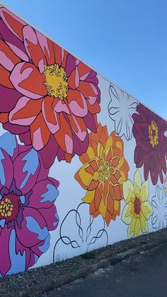 a large flowered mural on the side of a building next to a parking lot