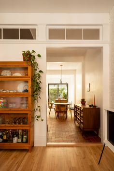 a living room filled with furniture and a fire place next to a dining room table