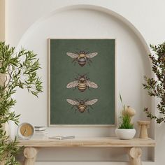 two bees sitting on top of a wooden shelf next to a potted green plant