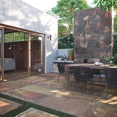 an outdoor dining area with patio furniture and stone walls