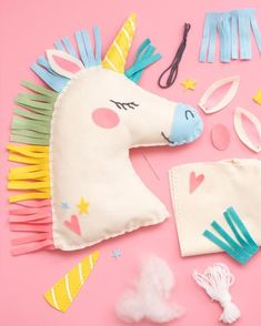 a unicorn mask and other accessories on a pink background