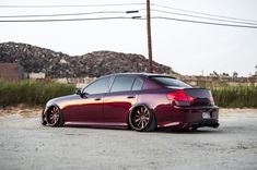 a maroon car parked on the side of a road