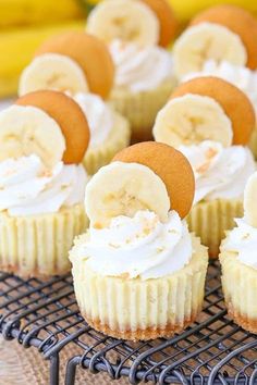 cupcakes with banana slices and whipped cream frosting on a wire cooling rack