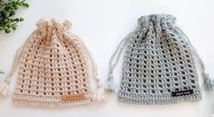 two crocheted bags sitting next to each other on top of a white table