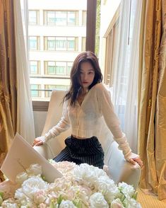 a woman standing in front of a bouquet of flowers