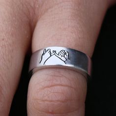 a close up of a person's hand with a wedding ring on their finger