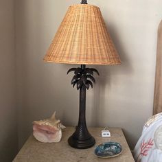 a lamp sitting on top of a wooden table next to a night stand and seashell