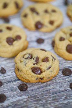 chocolate chip cookies on a wooden table with scattered chocolate chips