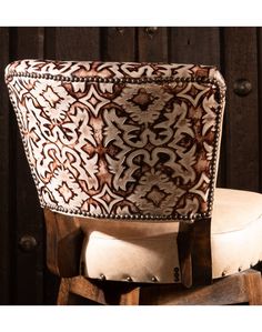 an upholstered chair sits on top of a wooden stool