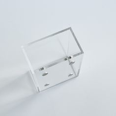 a clear plastic object with two holes in the middle on a white surface, it appears to be part of a piece of furniture