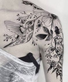 the back of a woman's shoulder with flowers on it and an pinterest logo