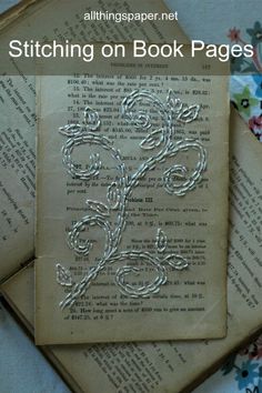 an old book with the title stitching on book pages written in silver threads