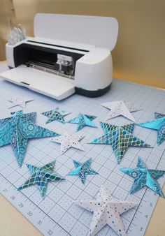 some blue and white stars are on a cutting board next to a cricut machine