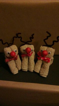 three stuffed animals with red noses and nose are sitting on a black surface in front of a cardboard box