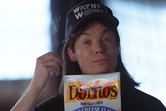 a man holding a bag of doritos in front of his face