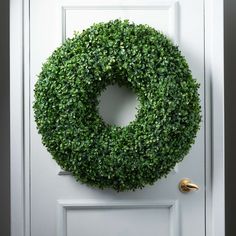 a green wreath hanging on the front door