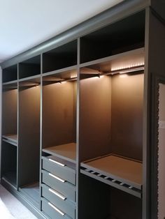 an empty walk in closet with drawers and lights