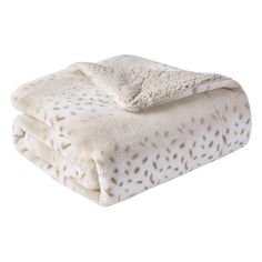 two blankets are folded on top of each other, one is white and the other has brown spots