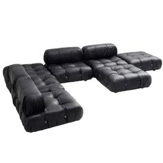 a set of black leather sofas with ottomans and footstools on white background