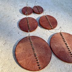 Distressed chestnut brown leather disks, with hand-sewn pyrite beads, hang from surgical steel ear wires. Three sizes and so light, you'll forget you're wearing them. Small; 1.75" L x 1.25" W Medium: 2.5L x 1.75W Large: 3"L x 2.25"W Handmade Leather Earrings Ideas, Leather And Metal Earrings, Simple Leather Earrings, Leather Halloween Earrings, Stamped Leather Earrings, Leather Earrings Ideas, Small Leather Projects, Leather Accessories Diy, Leather Stud Earrings